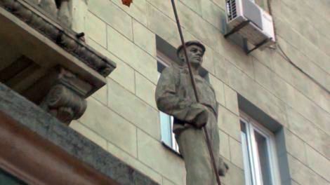 Socha slévaře na obytné budově ze stalinských dob